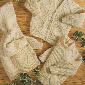 May include: Three knitted sweaters in a cream colour. One sweater has a hood, one has a button-up front, and one has a crew neck.