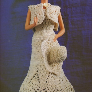 May include: A crocheted dress and hat set in a cream color. The dress has a fitted bodice and a flowing skirt with a scalloped hem. The hat is a wide-brimmed sun hat with a crocheted design.