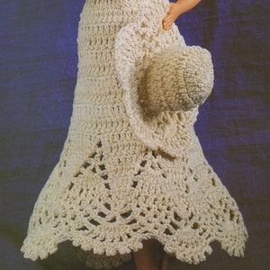 May include: A crocheted dress and hat set in a cream color. The dress has a flared skirt with a scalloped hem. The hat is a wide-brimmed sun hat.
