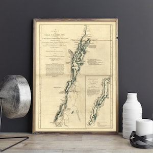 May include: A vintage map of Lake Champlain, including Lake George, showing the surrounding waterways and towns. The map is printed on aged paper with a brown border and a title in black text.