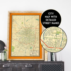 May include: A vintage-style map of Springfield, Missouri, with detailed street names. The map is framed in a light wood frame and is displayed on a black metal cabinet with a wire mesh door. The map is printed on a cream-colored paper with orange and green accents.