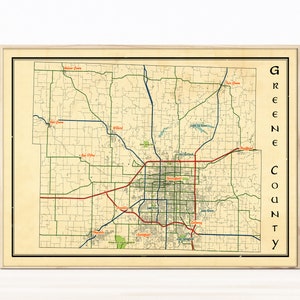 May include: A vintage map of Greene County, Missouri, with a beige background and green, blue, and red lines. The map shows the county's roads, rivers, and towns. The text "Greene County" is printed vertically on the right side of the map.