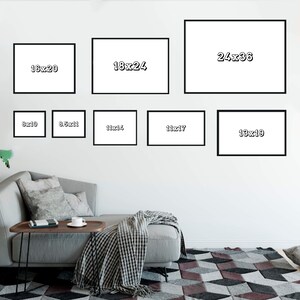 May include: A white wall with nine black frames of different sizes, each with a white background and black text indicating the dimensions of the frame in inches. The frames are arranged in a grid pattern, with the largest frame at the top center and the smallest frames at the bottom left and right.