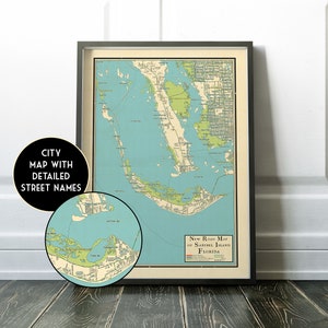 May include: A vintage style map of Sanibel Island, Florida, with detailed street names. The map is framed in a black frame and is displayed on a wooden floor. The map is printed in blue, green, and brown colors.