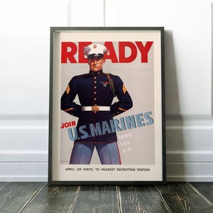 May include: A vintage poster with a red, white, and blue color scheme. The poster features a soldier in a blue uniform with a white hat and a red, white, and blue ribbon. The poster reads "READY JOIN U.S. MARINES LAND SEA AIR APPLY, OR WRITE, TO NEAREST RECRUITING STATION".