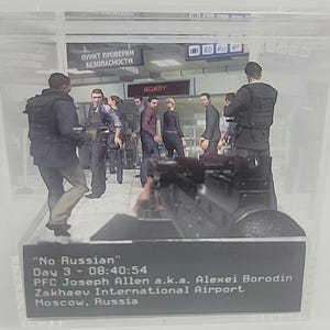 May include: A diorama depicting a scene at an airport security checkpoint. Figures of people are visible, with a weapon in the foreground. Text includes "No Russian", time, and location details. The scene is enclosed in a clear display case.