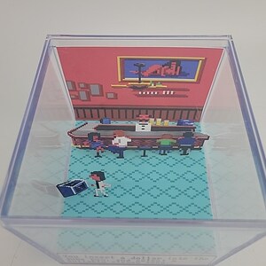 Puede incluir: Diorama pixelado dentro de una caja de pl&aacute;stico transparente. La escena representa un bar con clientes, un barman y una persona con un cofre del tesoro. El fondo es rojo con arte enmarcado. El suelo tiene un patr&oacute;n de diamantes turquesa.