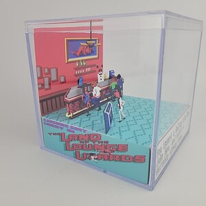 Puede incluir: Diorama en miniatura de una escena de bar dentro de una caja de pl&aacute;stico transparente. La escena presenta figuras pixeladas, una barra y un letrero que dice "The Land of the Lounge Lizards". El fondo es rojo con arte enmarcado.