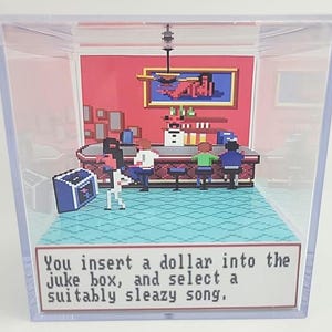 Pode incluir: Um diorama pixelizado dentro de uma caixa de acrílico transparente. A cena retrata um bar com clientes, uma jukebox e uma placa que diz: "Você insere um dólar na jukebox e seleciona uma música suja."