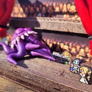 May include: A purple tentacled creature with white teeth and pixelated figures on a wooden surface. Red curtains are visible in the background. The scene evokes a fantasy or gaming theme.