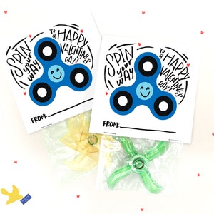 May include: Two Valentine's Day gift tags with a blue fidget spinner design. The tags say "Spin your way to a Happy Valentine's Day!" and have a space to write "From:".