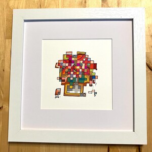 May include: A framed abstract art piece with a white border. The artwork features a colorful, geometric design composed of squares and rectangles in shades of red, green, yellow, and gold. The artwork is signed in the lower left corner.