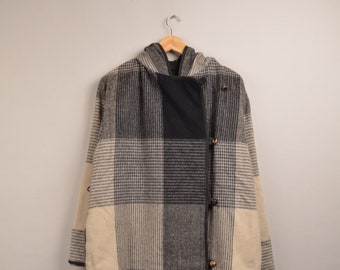 May include: A long, hooded coat with a plaid pattern in shades of beige, gray, and black. The coat has a button closure and a relaxed fit.
