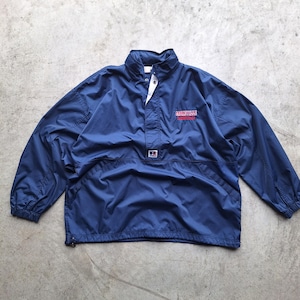 Könnte beinhalten: Marineblauer Windbreaker mit hohem Kragen und halbem Reißverschluss. Der Schriftzug "CINCINNATI" ist in Rot auf die Brust gestickt. Die Jacke hat lange Ärmel und einen Kordelzug am Saum. Ein kleines Logo ist sichtbar.