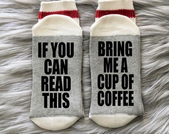 May include: A pair of gray and white socks with red stripes. One sock says "If you can read this" and the other sock says "Bring me a cup of coffee".