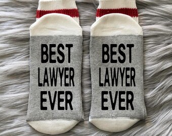 May include: A pair of gray and white socks with red trim. The socks have the text "BEST LAWYER EVER" printed on them.