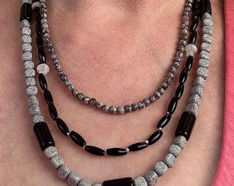 Rain Clouds. 3 strands of Black Obsidian, Black Spinel, Black Spotted Feldspar, Gray Crazy Lace Agate and Moonstone. Adjustable hook clasp