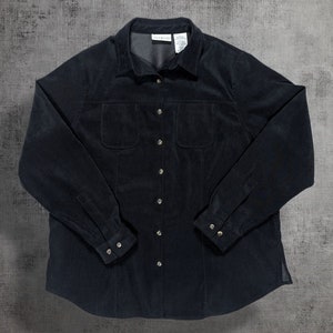 May include: A black corduroy button-down shirt with long sleeves and two chest pockets.