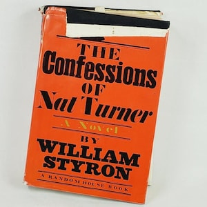 May include: A vintage paperback book titled "The Confessions of Nat Turner" by William Styron. The book has an orange cover with black lettering and a white label at the top. A Random House Book.