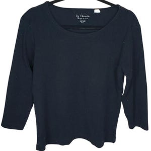May include: A navy blue, scoop-neck top with three-quarter sleeves. The top features the brand name "by Chico's" on a small tag near the neckline. The shirt is made of a soft, comfortable material.