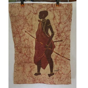 May include: An African-themed artwork depicting a silhouetted figure in a maroon garment, holding a spear and a sword. The figure is adorned with gold jewelry. The background features a textured, light brown pattern with reddish-brown veins, creating a batik-like effect.
