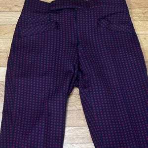 May include: Black pants with a red and black checkered pattern.