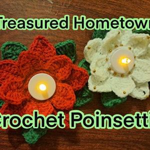 Puede incluir: Dos portavelas de poinsettia de ganchillo, uno rojo y otro blanco, con velas de té en su interior. El texto "Treasures Hometown Crochet Poinsettia" es visible debajo de los portavelas.