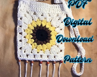 Op de afbeelding: Witte gehaakte zonnebloem crossbody tas met een bruin en geel centrum. De tas heeft een franje rand en een witte band. De tekst "PDF Digitaal Download Patroon" is in blauw op een witte achtergrond geschreven.