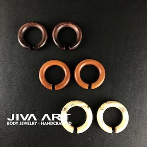 May include: Three pairs of wooden ear gauges in different wood tones. The top pair is dark brown, the middle pair is light brown, and the bottom pair is a light wood with brown streaks.