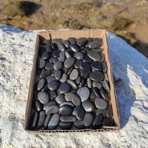 100~150 ciottoli di spiaggia ovali e rotondi, lisci, neri e grigio scuro. Pietre di spiaggia piatte e lucidate naturalmente. Tessere di mosaico naturali.