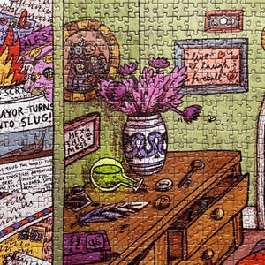 May include: A colorful jigsaw puzzle featuring a whimsical illustration. The puzzle depicts a wooden desk with a vase of purple flowers, a green potion bottle, and framed artwork. Text includes "Mayor Turns Into Slug!" and "Live, Laugh, Fireball!"