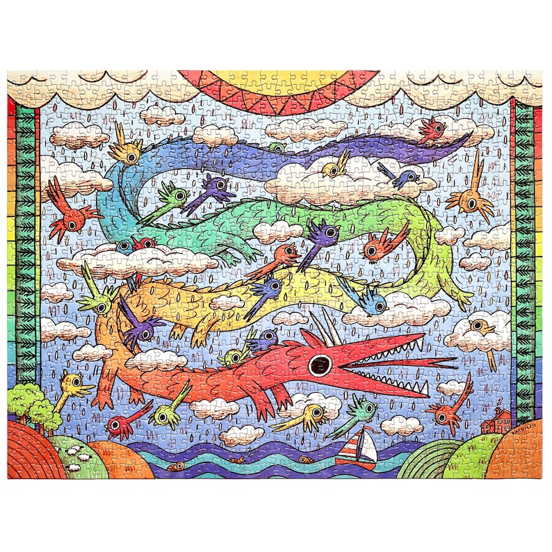 May include: A jigsaw puzzle featuring a colorful illustration of three long, serpentine dragons in red, yellow, and green, flying through a rainy sky filled with clouds, small birds, and a sun. A sailboat and hills are visible at the bottom.