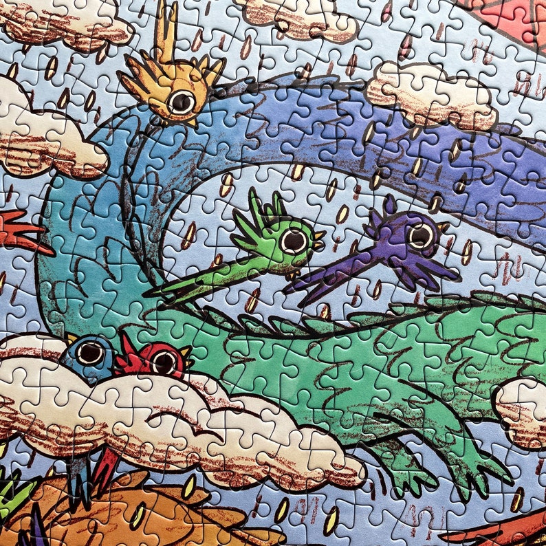 May include: A jigsaw puzzle featuring a colorful illustration of stylized birds in flight against a blue sky with clouds and rain. The scene includes a large green creature, a yellow bird, a green bird, a purple bird, and a blue and red bird.