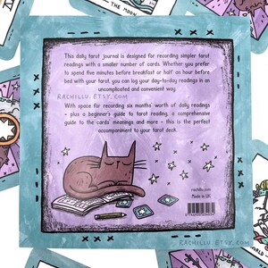 May include: A purple and teal tarot journal with a cat illustration on the cover. The journal has space for six months of daily readings, a beginner's guide to tarot reading, and a comprehensive guide to the cards' meanings. The text on the cover reads "This daily tarot journal is designed for recording simpler tarot readings with a smaller number of cards. Whether you prefer to spend five minutes before breakfast or half an hour before bed with your tarot, you can log your day-to-day readings in an uncomplicated and convenient way. RACHILLU. ETSY.COM With space for recording six months' worth of daily readings - plus a beginner's guide to tarot reading, a comprehensive guide to the cards' meanings and more - this is the perfect accompaniment to your tarot deck."