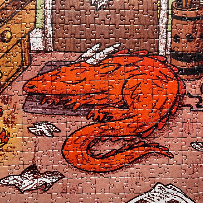 May include: A completed jigsaw puzzle featuring a cartoon dragon in shades of orange and red. The dragon is curled up on a brown surface, with white accents on its horns and wings. The puzzle pieces are tan.