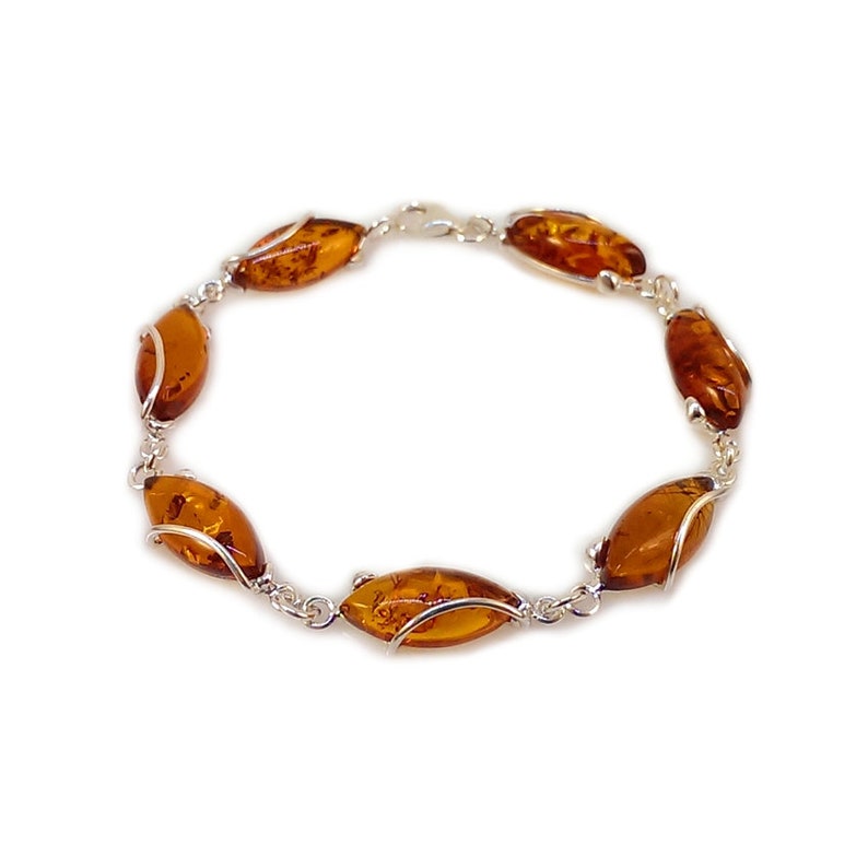 May include: A silver bracelet with six amber oval-shaped stones. The stones are set in a silver wire design.