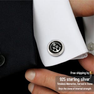 May include: A pair of silver cufflinks with a black onyx inlay featuring an anchor and the initials "KB".
