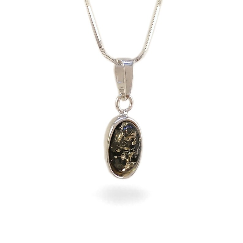 May include: A silver chain necklace with a pendant featuring a dark green oval-shaped stone.