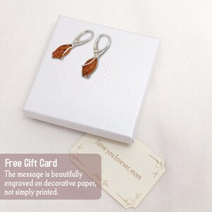 May include: A pair of silver earrings with amber stones. The earrings are in a white box with a gift card that says "I love you forever, mom".