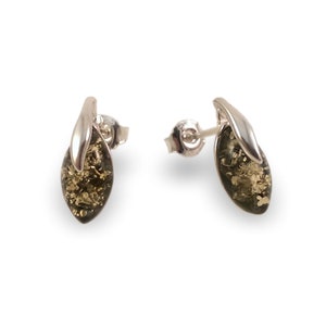May include: A pair of silver earrings with green amber stones. The stones are oval shaped and have a leaf-like design on the top.