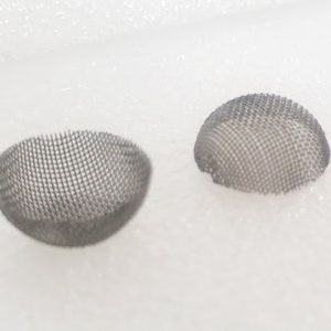Puede incluir: Dos cuencos de malla metálica de color plateado, cada uno con un diseño redondeado en forma de cúpula. Los cuencos están sobre una superficie blanca.