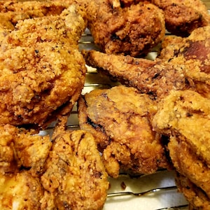 May include: A close-up of a plate of crispy fried chicken. The chicken is golden brown and has a crunchy exterior.