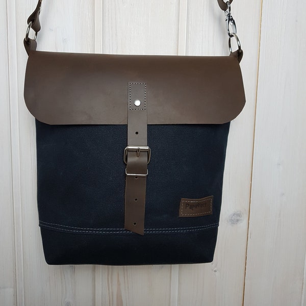 Schoudertas in waxed doek in zwart met flap in koeienhuid, zwarte waxed canvas en lederen flap tas