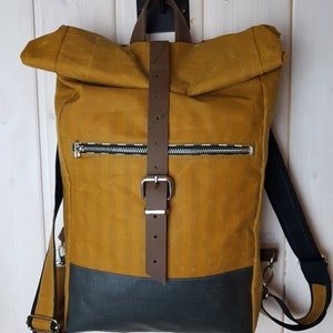 Rucksack mit Falttop aus ockerfarbenem Oilskin, komijnkleurige oilskin rugzak met gevouwen bovenkant