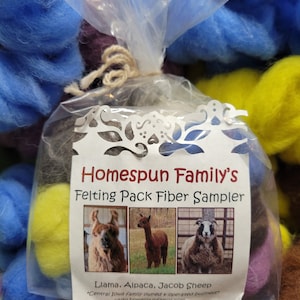 May include: A clear plastic bag filled with colorful wool fiber for felting. The bag has a label that reads "Homespun Family's Felting Pack Fiber Sampler" and includes pictures of a llama, alpaca, and Jacob sheep. The label also states "Central Iowa family owned & operated business" and "www.homespunfamily.com".