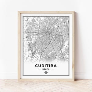 Op de afbeelding: Een zwart-witte kaartprint van Curitiba, Brazilië, met een kompasroos en de stadsnaam in een zwart sans-serif lettertype.