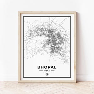 Op de afbeelding: Een zwart-witte kaartprint van Bhopal, India, met een kompasroos en de stadsnaam in een zwart sans-serif lettertype.