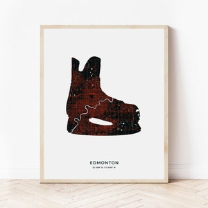 May include: A black and red hockey skate outline filled with a map of Edmonton, Alberta, Canada. The text "EDMONTON 53.5444° N, 113.4869° W" is below the skate.