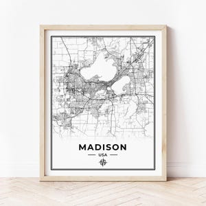 Puede incluir: Impresión de un mapa de Madison, EE. UU., en blanco y negro, con una rosa de los vientos en el centro inferior. El mapa muestra las calles y los lagos de la ciudad.