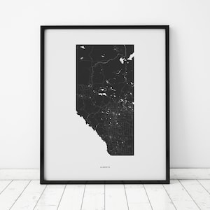 Puede incluir: Impresión de un mapa en blanco y negro de la provincia de Alberta, Canadá, en un marco negro. El mapa muestra las carreteras, ríos y lagos de la provincia. La palabra "ALBERTA" está impresa en blanco en la parte inferior del mapa.
